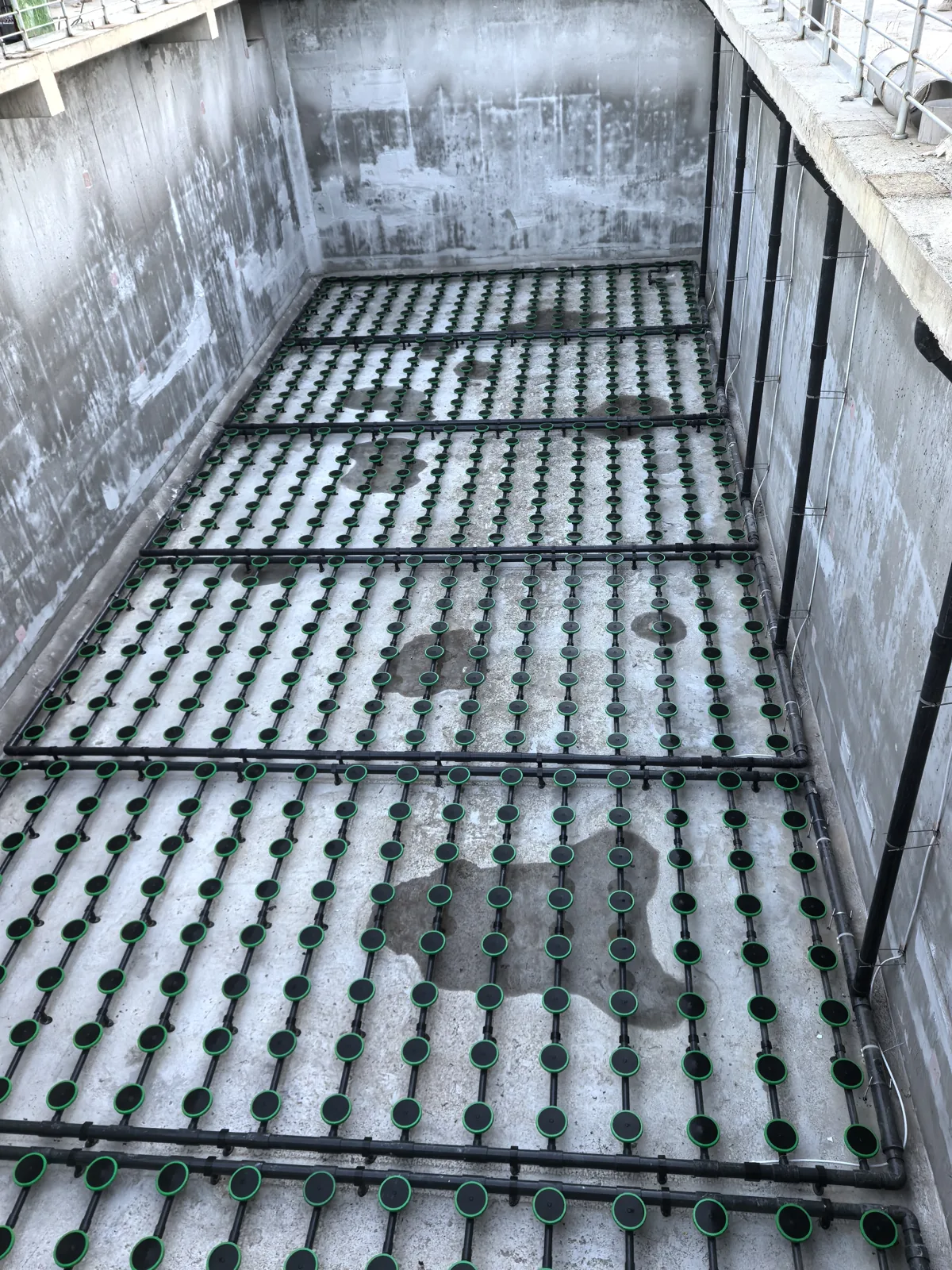 Disc diffusers installed across an empty aeration tank