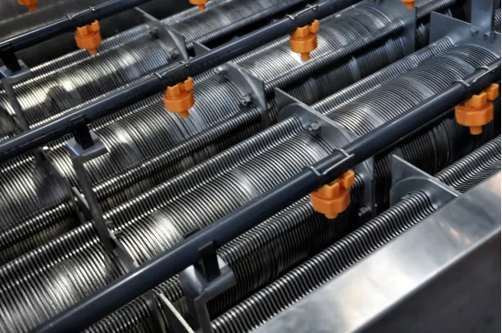 Close-up of screw press disc stacks and wash-water spray nozzles